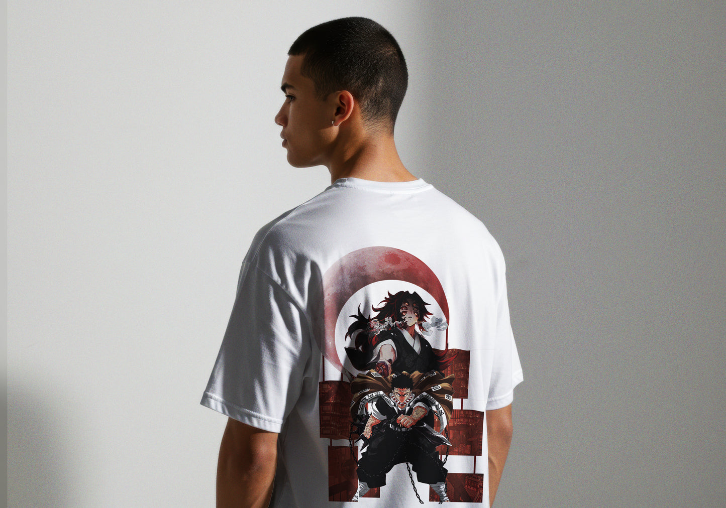 Person wearing a white t-shirt with a graphic design on the back against a plain background