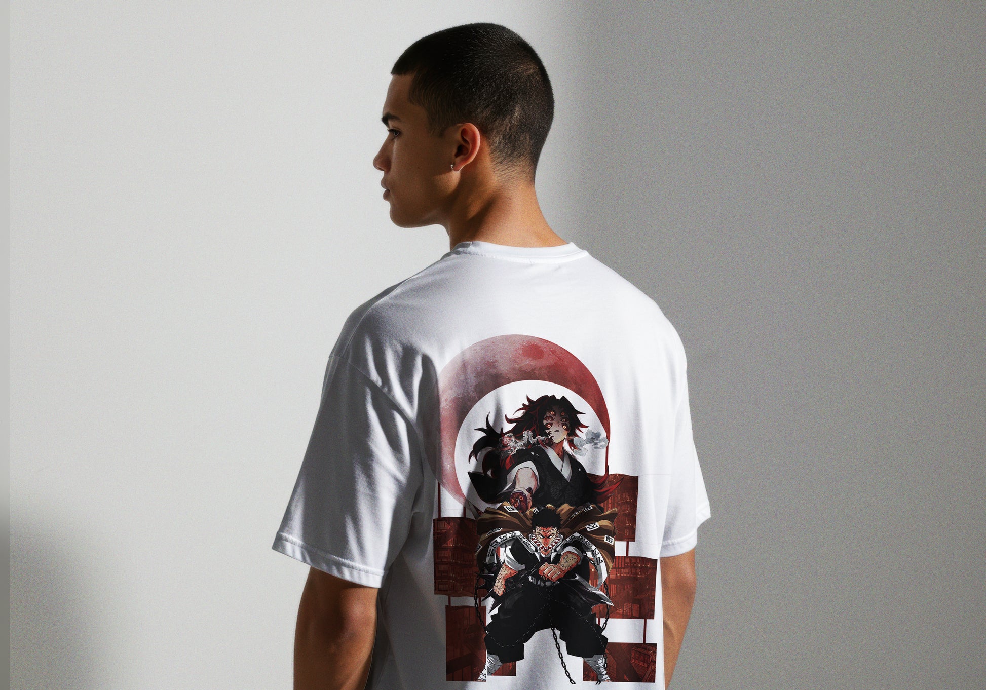 Person wearing a white t-shirt with a graphic design on the back against a plain background